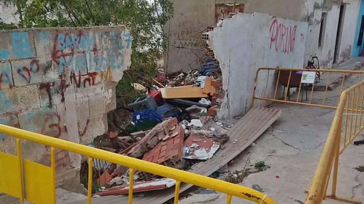 El muro se ha venido abajo tras ceder la calle y agrandarse uno de los socavones de la vía. | INFORMACIÓN