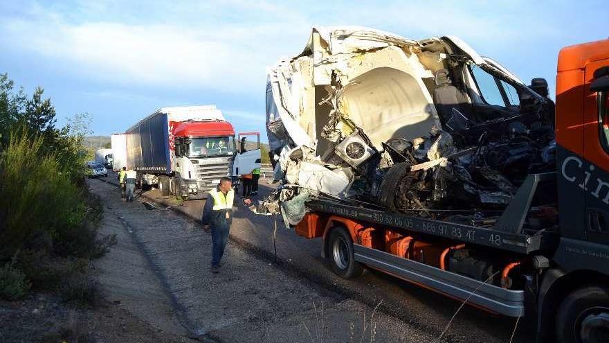 La furgoneta siniestrada en cargada en una grúa para su retirada de la vía.