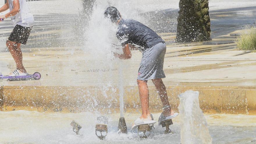 Niños se refrescan en una fuente de Elche debido a la ola de calor