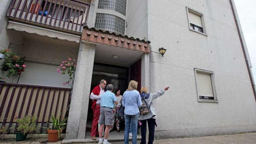 Vecinos del inmueble señalan la ventana del bajo donde tuvo lugar el homicidio. // Marta G. Brea