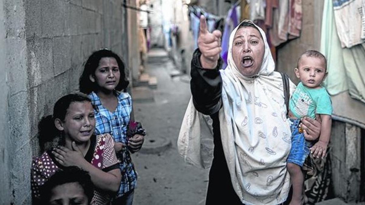 Una mujer palestina llora tras la explosión en un patio cerca del mar, en Gaza.