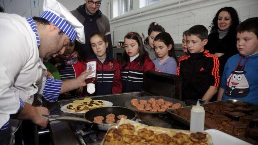 Niños del colegio de Soutelo y sus profesores, ayer, aprendiendo a cocinar con el cocinero Rubén García.  // Bernabé / Javier Lalín