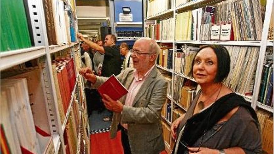 Josep M. Terricabras i Milena Carrara revisen els llibres de Panikkar tal com han quedat instal·lats a la UdG.