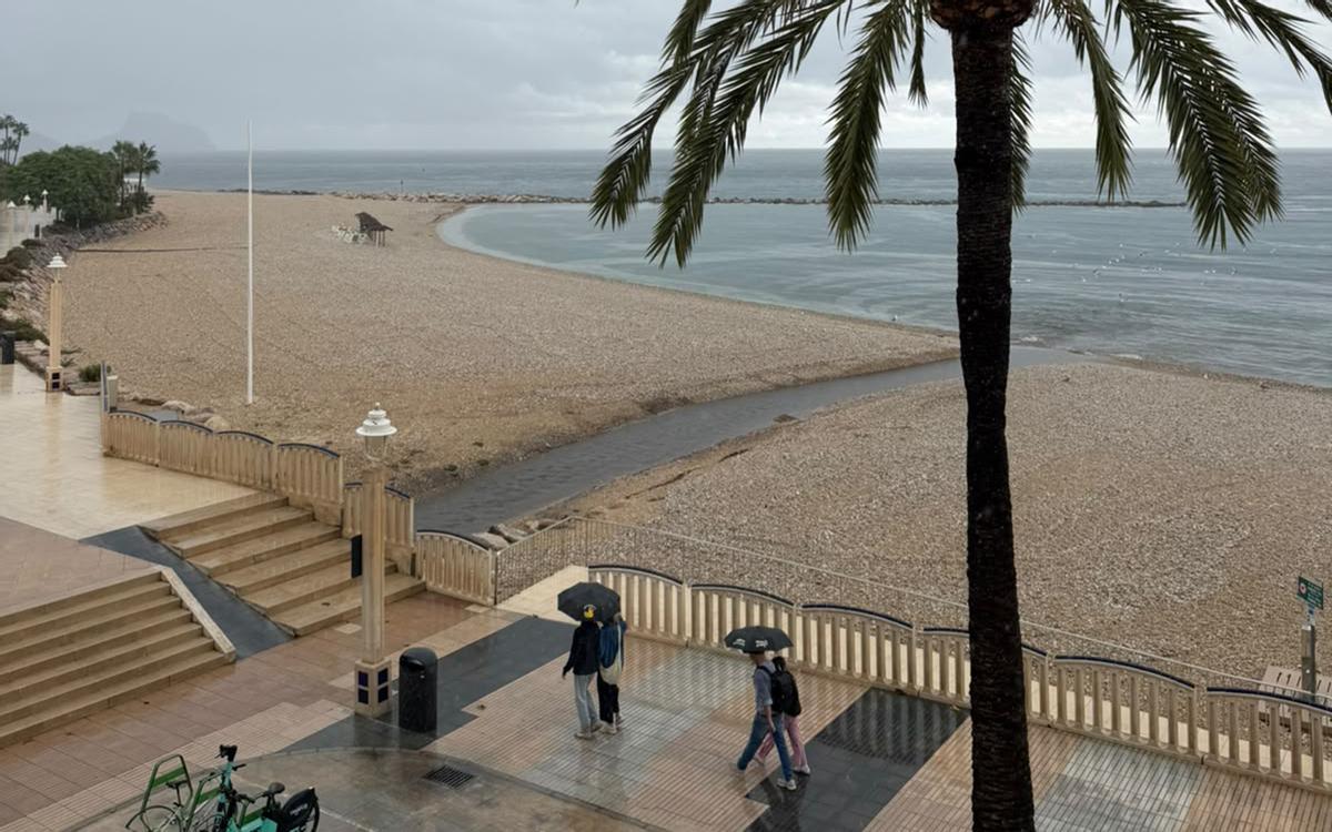 Unos ciudadanos transitan por el paseo marítimo de Altea esse domingo.