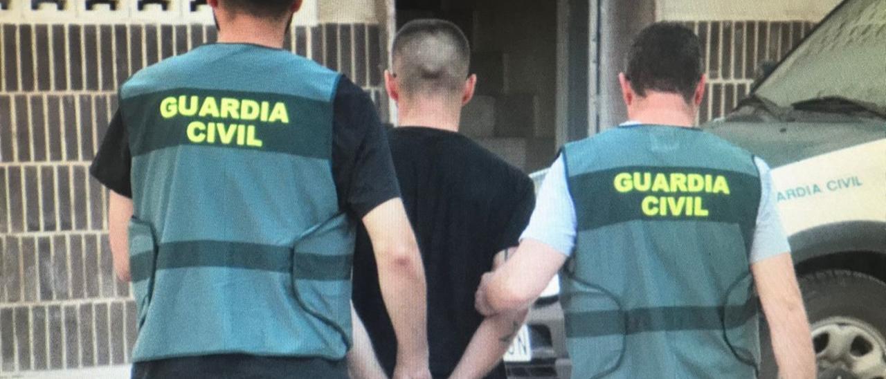 Agentes de la Guardia Civil de Villena conducen a uno de los detenidos a los calabozos del cuartel.