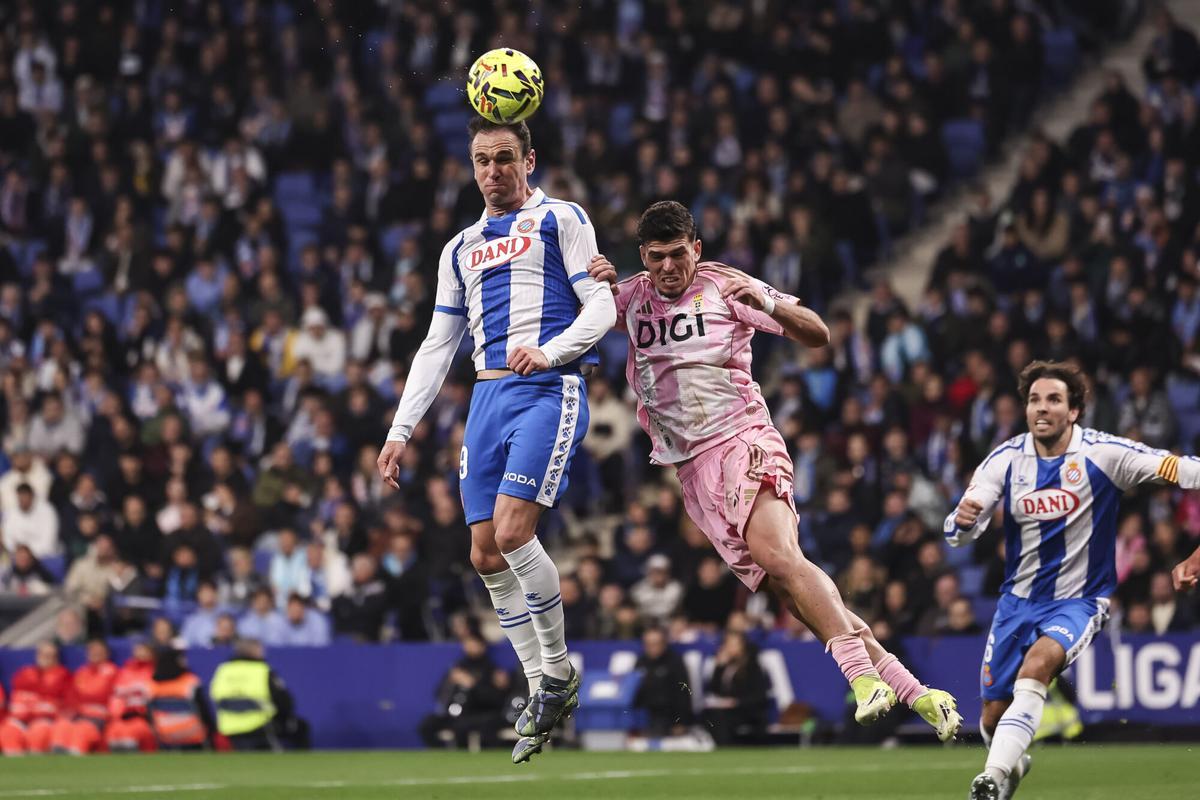 Kike García, del Espanyol, cabecea un balón junto a Javi López, del Oviedo.