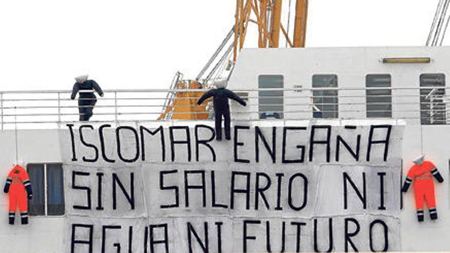 Los tripulantes han colgado una pancarta con la que protestan por su situación.