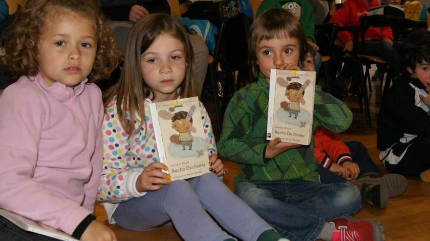 Un grupo de escolares de los Oscos, con libros de Gonzalo Moure; en primer término, por la izquierda, los niños María, Silvana y Aritz.