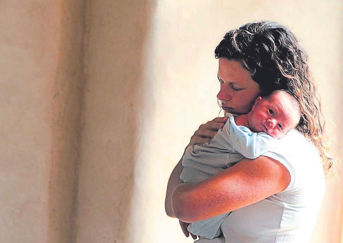 Una madre con un bebé en brazos.