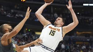 Denver Nuggets center Nikola Jokic, right, shoots for a basket over Minnesota Timberwolves center Rudy Gobert in the first half of an NBA basketball game Tuesday, April 1, 2025, in Denver. (AP Photo/David Zalubowski)