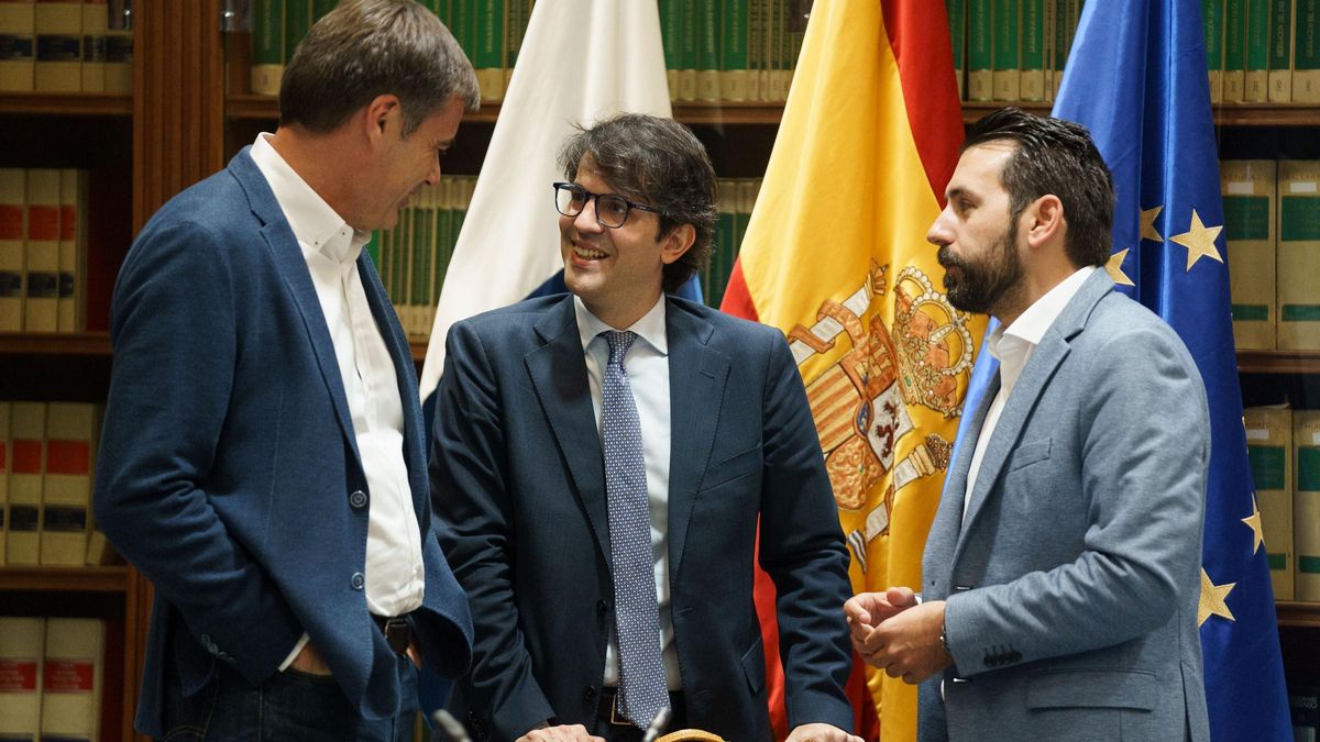 Pablo Hernández (c) conversa con los diputados Fernando Enseñat (i) y Manuel Herández (d) antes de su comparecencia en el Parlamento.