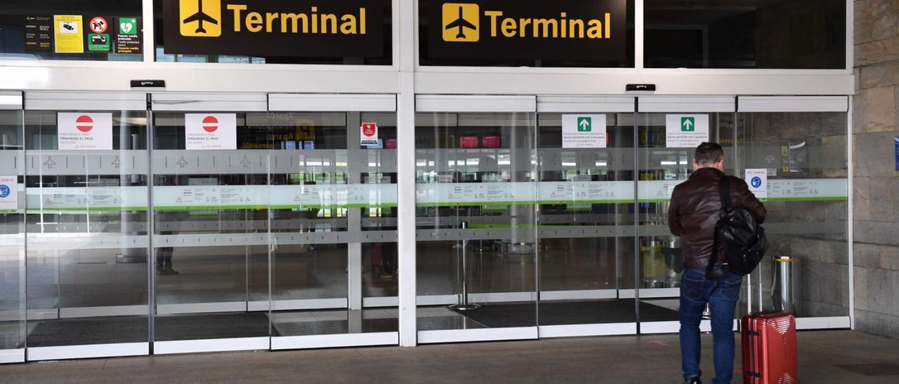 Un hombre se dispone a entrar en el aeropuerto de Alvedro. |   // VÍCTOR ECHAVE