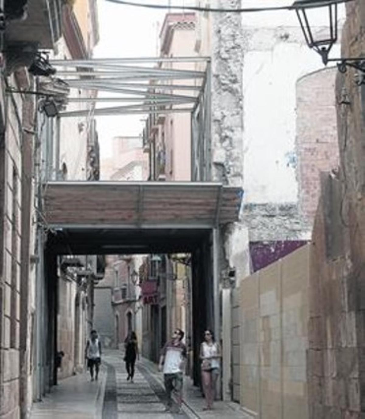 Uns transeünts passen sota un arc de protecció al carrer de Cavallers. Uns transeünts passen sota un arc de protecció al carrer de Cavallers.