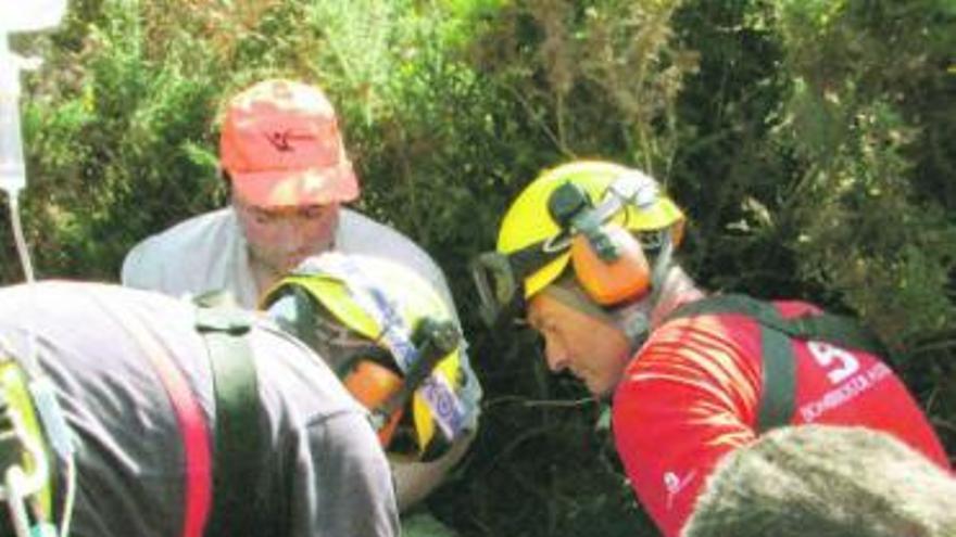 Los miembros de Bomberos de Asturias asisten al herido antes de su traslado en helicóptero al Hospital Central.