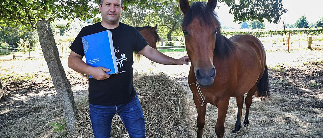 O filólogo, profesor e concelleiro Fernando Groba, coa súa tese e dous dos seus cabalos.   | // ANXO GUTIÉRREZ