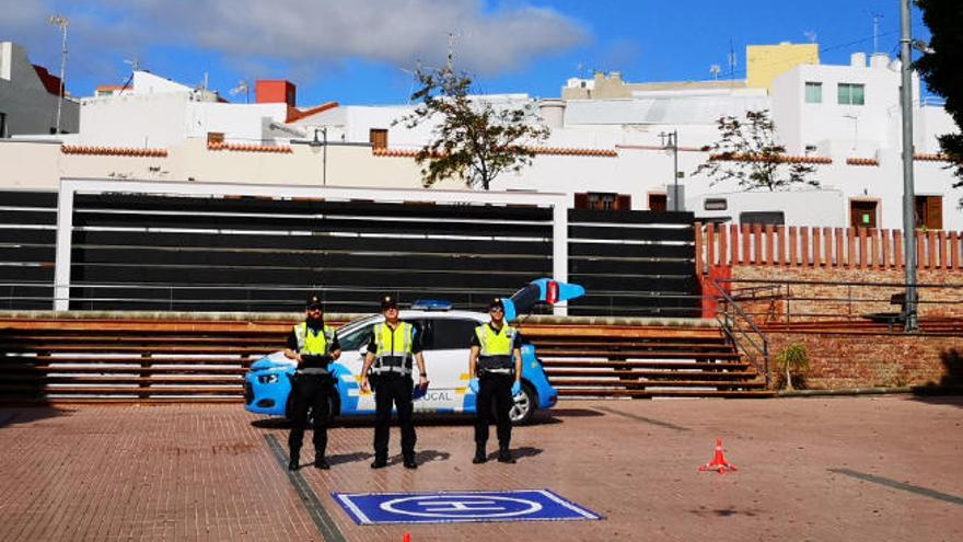 Los tres agentes de la Unidad de la Policía Local, ayer, con el dron en la plaza de la Candelaria.