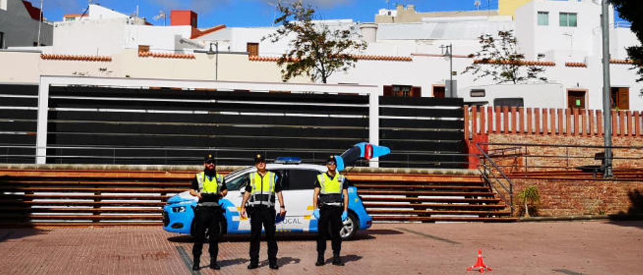 Los tres agentes de la Unidad de la Policía Local, ayer, con el dron en la plaza de la Candelaria.