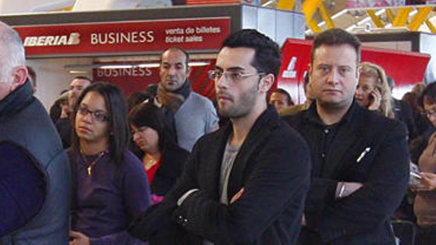 Pasajeros esperan su turno en la zona de facturación de la T4 del aeropuerto de Barajas, en Madrid.