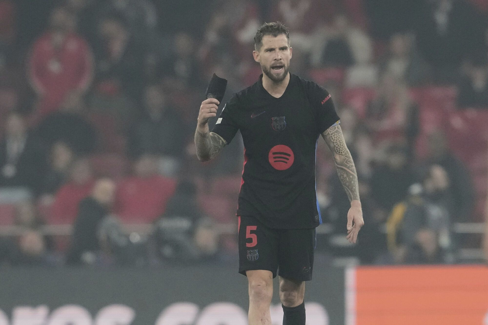 Barcelona's Inigo Martinez gestures after a foul during the Champions League round of 16 first leg soccer match between SL Benfica and FC Barcelona at the Luz stadium in Lisbon, Wednesday, March 5, 2025. (AP Photo/Armando Franca)