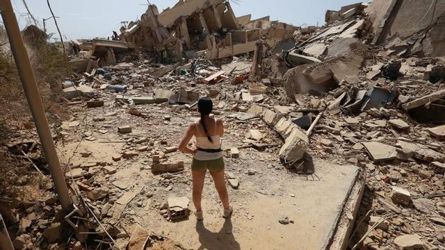Una jove de La Guaira contempla la runa de diverses cases esfondrades després del devastador terratrèmol a Veneçuela. | JAVIER CAMPOS / DPA