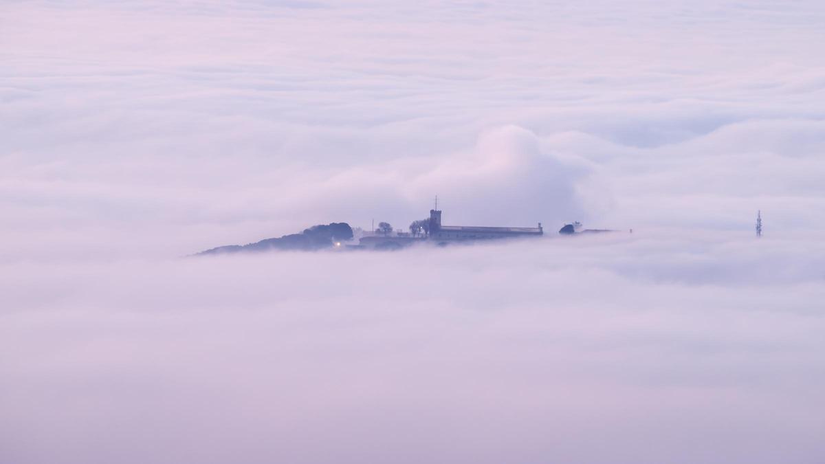 Empieza el 18 de marzo del 2024 con muchas nubes bajas en la fachada marítima de Barcelona. En la imagen, el castillo de Montjuïc asoma entre las nubes bajas.