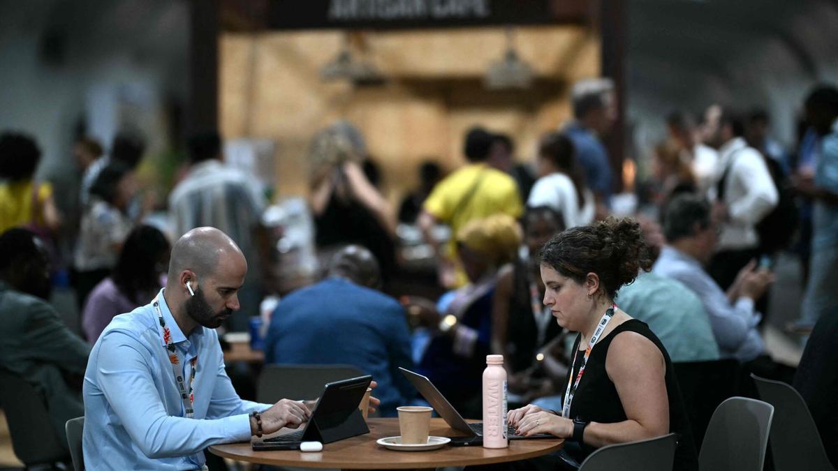 Varias personas trabajan desde el interior del recinto que acoge la cumbre del clima de Belém (COP30).
