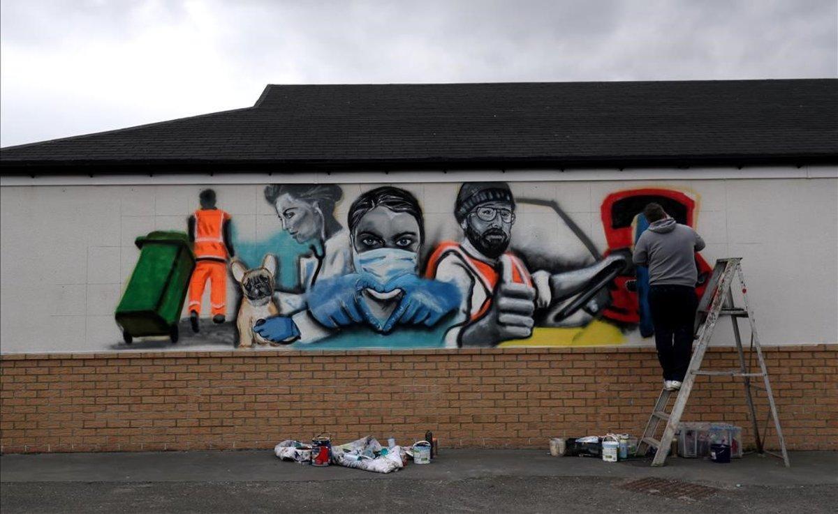 Un artista pinta un mural de apoyo al sistema nacional de salud en la localidad inglesa de Marske-by-the-Sea. 