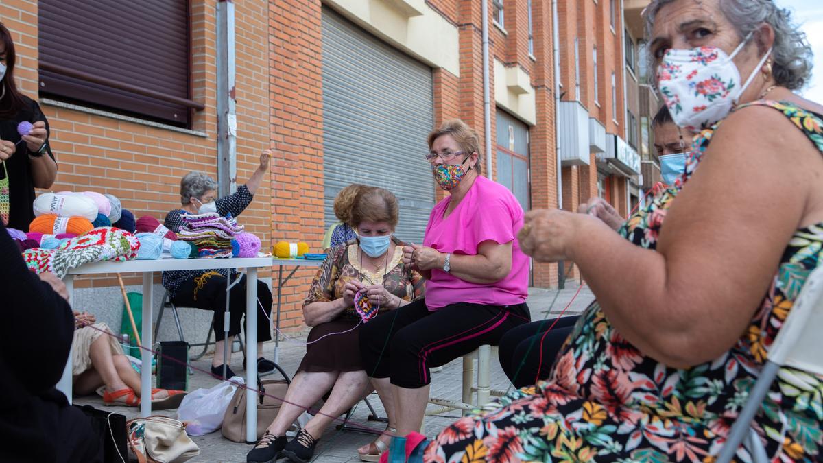 Mujeres de San José Obrero tejen un mural de ganchillo.