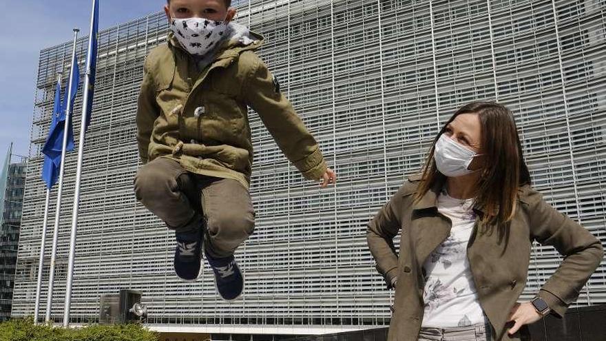 Un niño, junto a su madre, juega ayer frente a la sede de la Comisión Europea. // Reuters