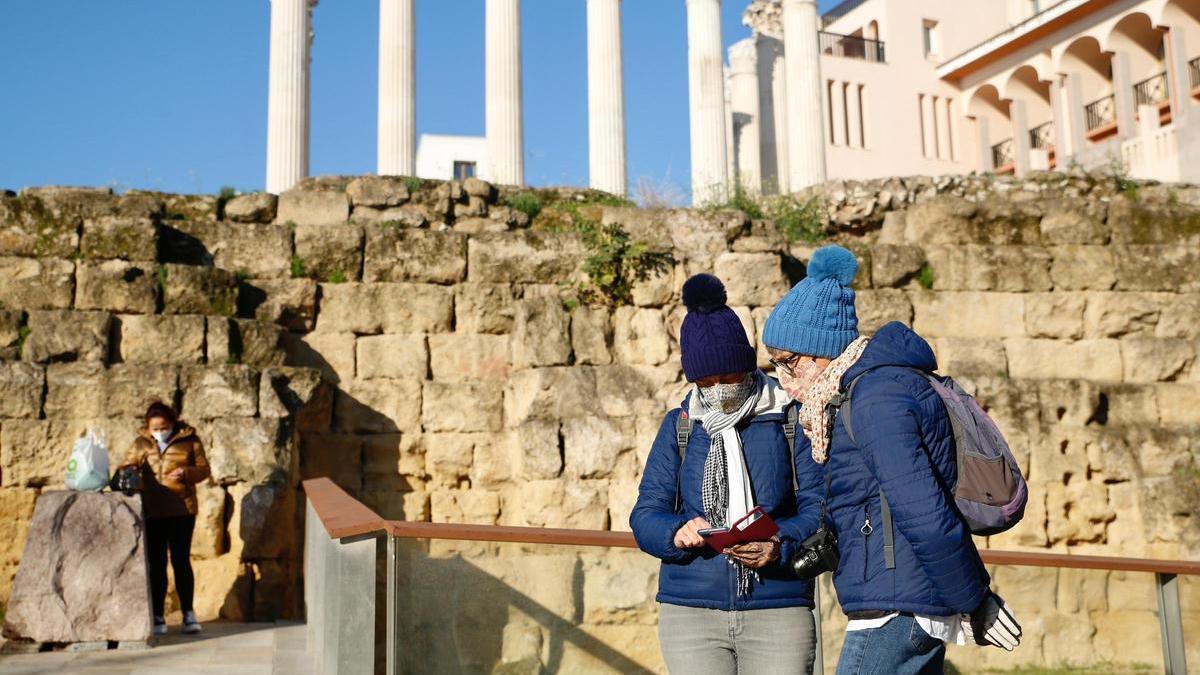 Personas abrigadas para hacer frente al frío junto al Templo Romano de Córdoba.