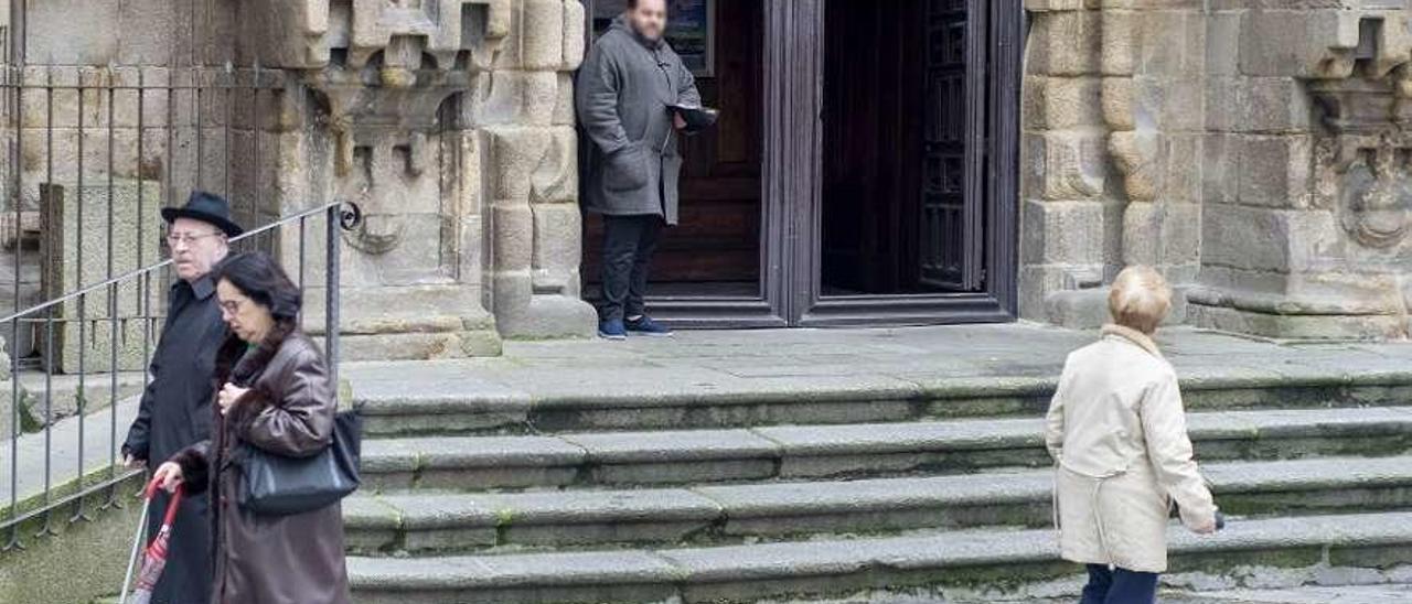 Una persona pidiendo a la salida de la iglesia de Santa Eufemia. // Carlos Peteiro