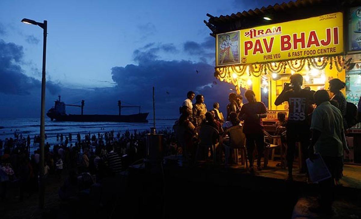 Un grup de persones es concentren aquest dilluns per observar el navili ’MW Wisdom’, que ha quedat encallat a la platja de Juhu, a Bombai. El corrent i el fort vent han portat el vaixell, de Sri Lanka, fins a la platja, on s’ha convertit en una atracció local.