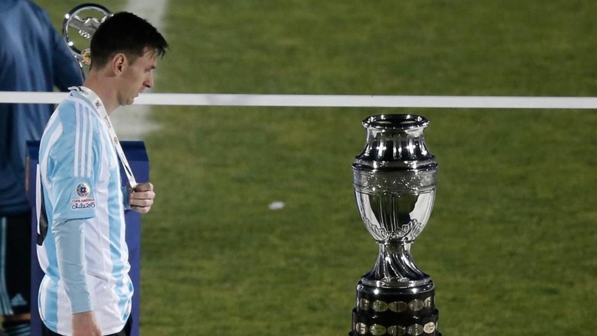 El delantero argentino Leo Messi mira cabizbajo la Copa América tras perder la final ante Chile en los penaltis