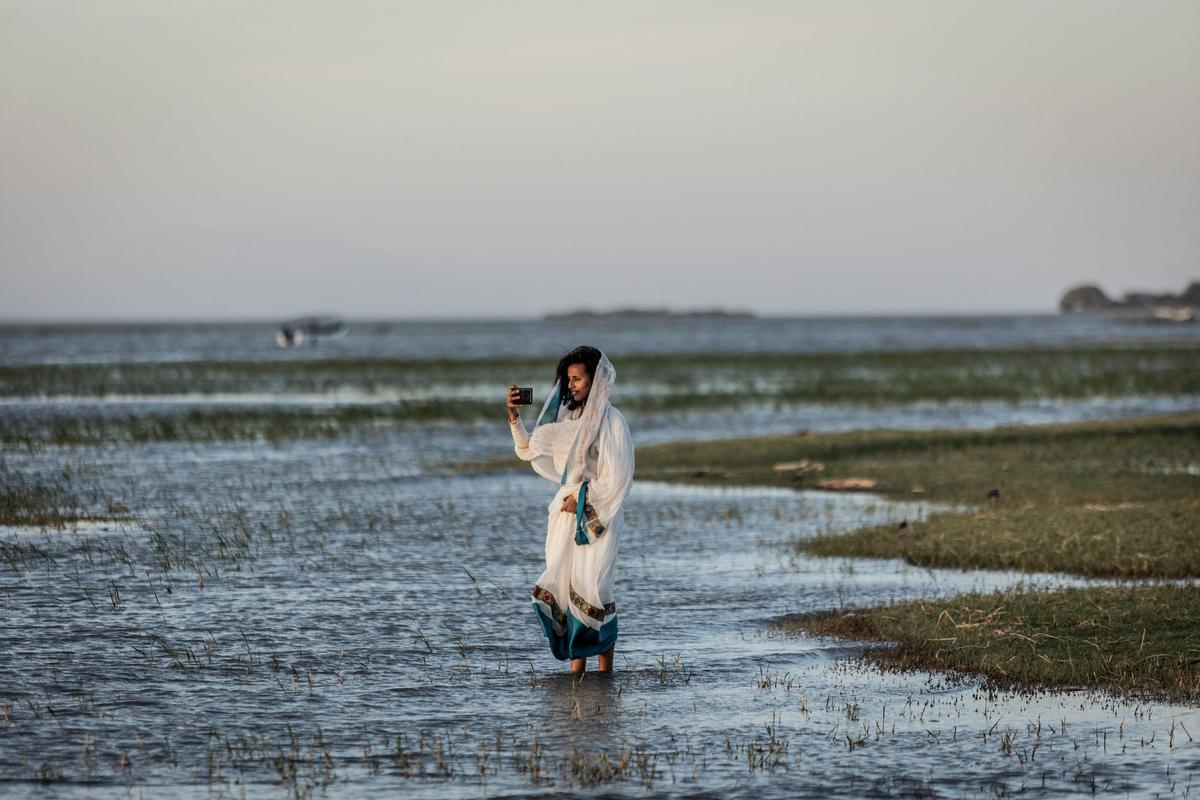 Los devotos ortodoxos etíopes asisten a una oración durante la celebración de la Epifanía de Etiopía en la orilla del lago Batu, Etiopía