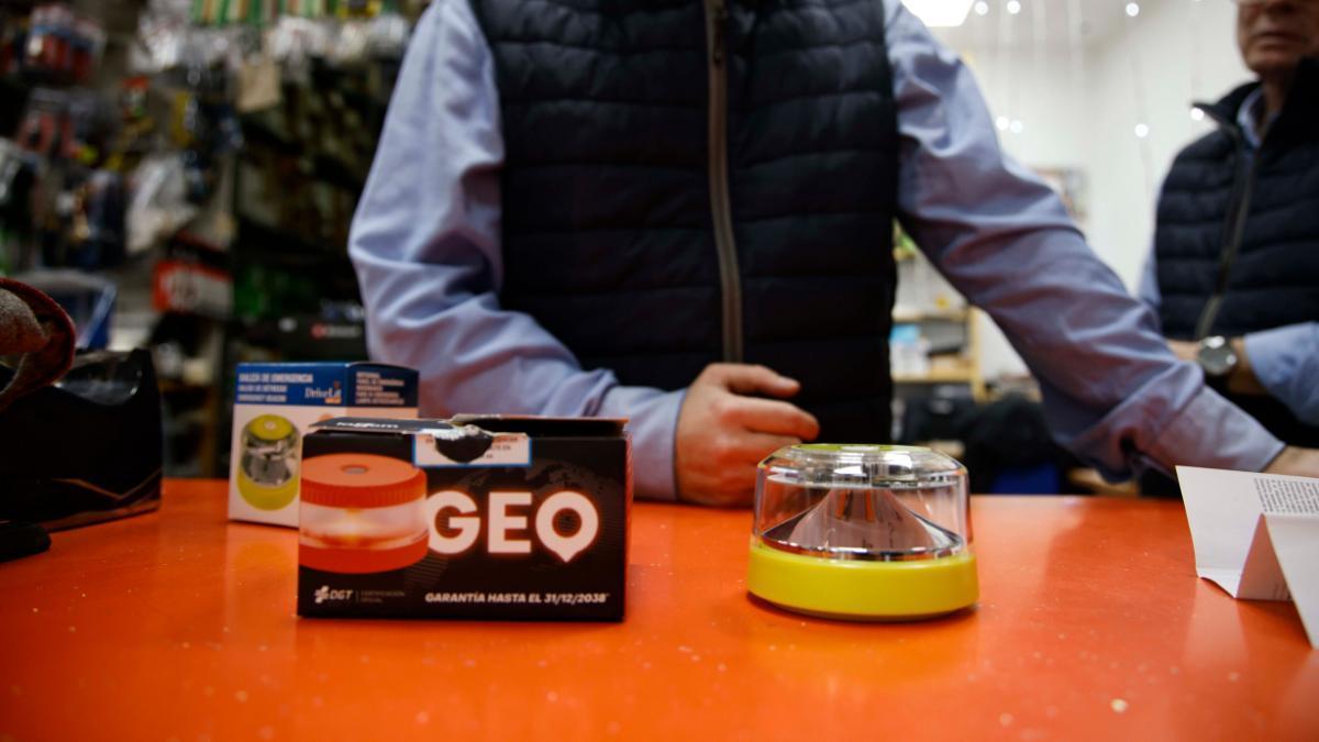 Un vendedor muestra las balizas V16 que tiene en su tienda.