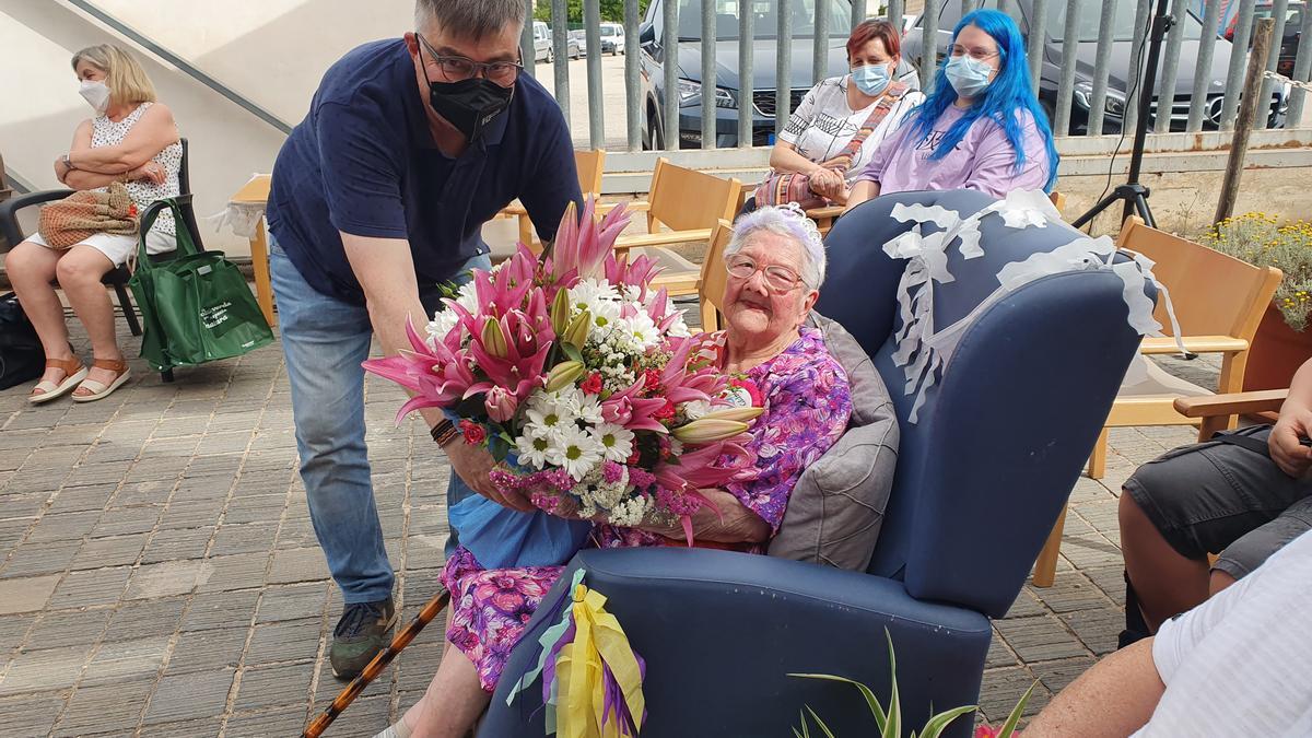 El alcalde de Montuïri entrega un ramo de flores a Catalina Bujosa con motivo de su 106 aniversario.
