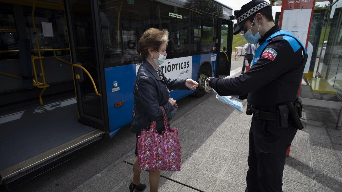 Un agente policial verifica que los viajeros a bordo de un autobús tienen motivos justificados para el desplazamiento.