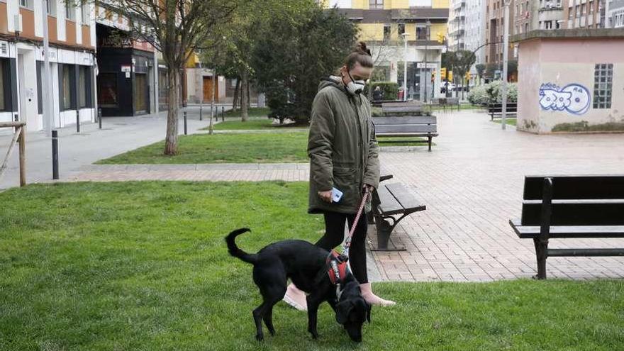 Victoria Álvarez, ayer, paseando a su perro por la plaza de Compostela, en El Llano.