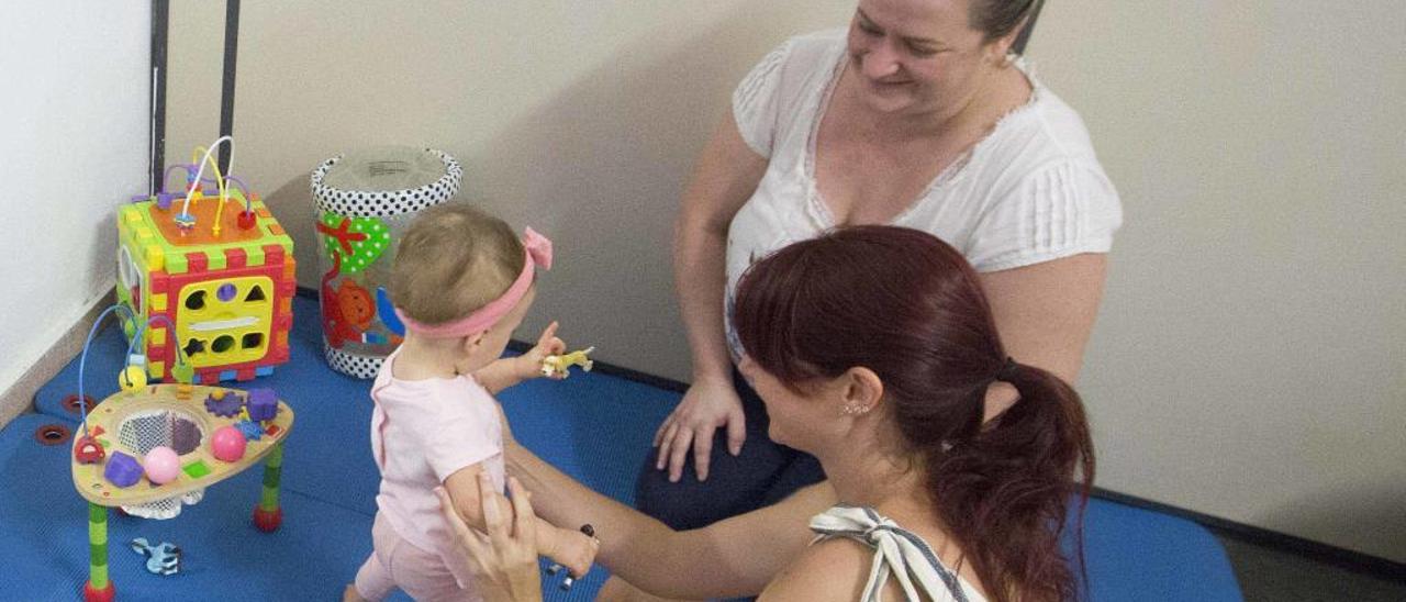 La pequeña Triana, con su madre y la especialista, se pone en pie y gatea tras un año de rigidez.