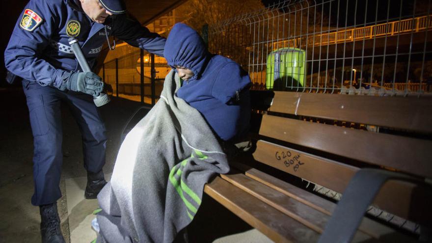 Un policía localatiende a una persona sin techo durante la operación frío.