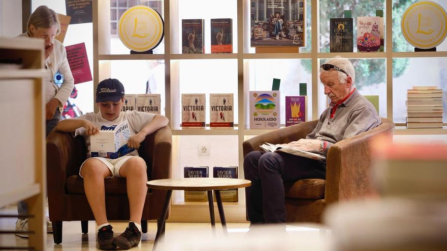 Dos lectores disfrutan de sus respectivos libros en La Casa del Libro.