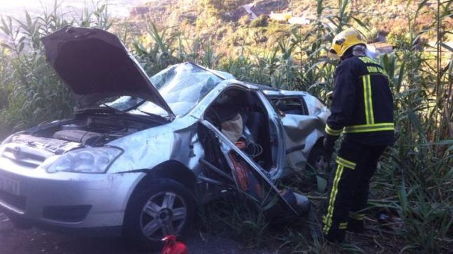 Un bombero junto al coche accidentado ayer en Cuesta Falcón. | la provincia / dlp