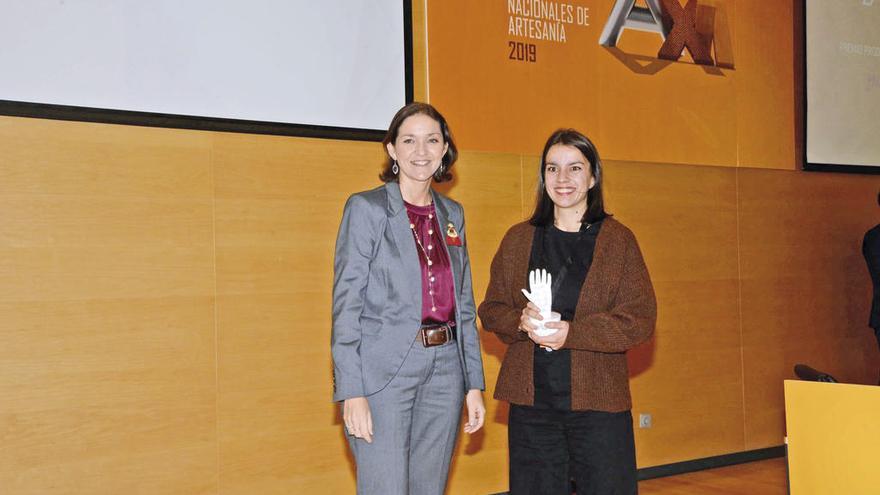 Paula Ojea recogiendo el premio de la mano de Reyes Maroto. // FdV