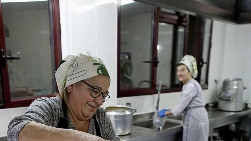 Voluntarios, ayer, en la cocina del Albergue Covadonga, preparando cenas.