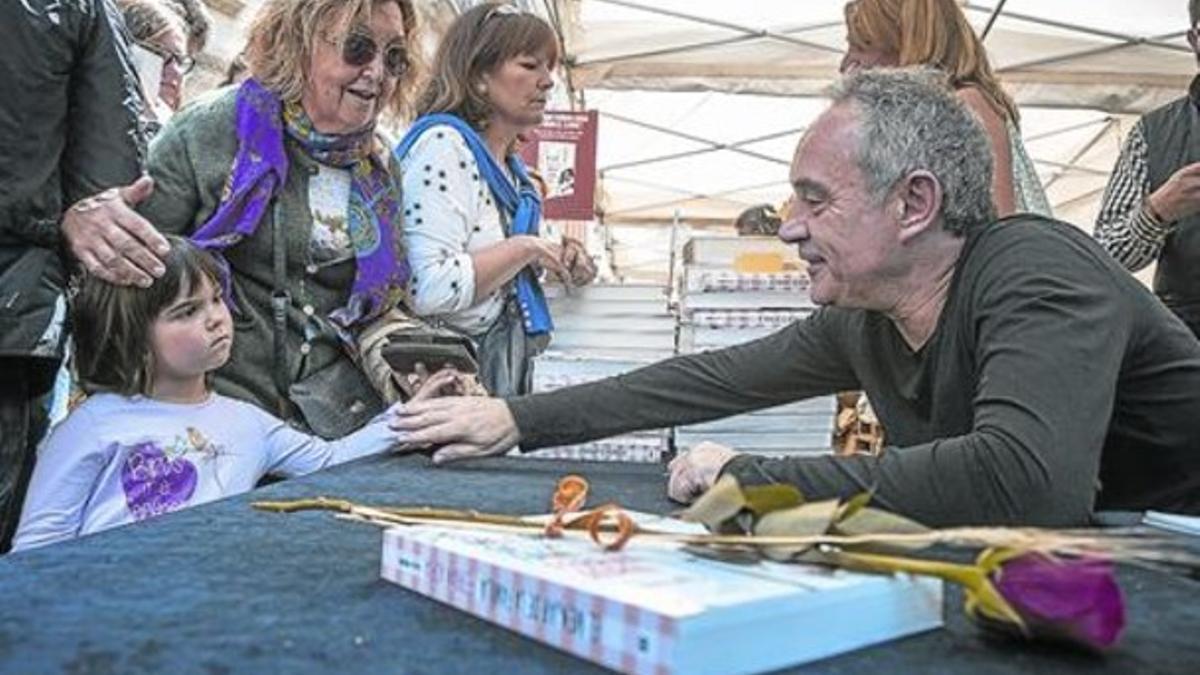 Ferran Adrià saluda a una niña, ayer, durante la firma de su libro 'La comida de la familia' en el paseo de Gràcia.