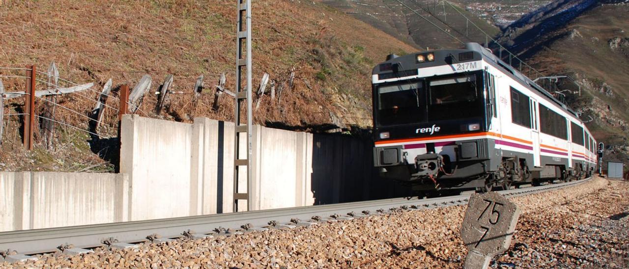 Un tren regional circula por la trinchera de Los Llanos, en la rampa de Pajares.