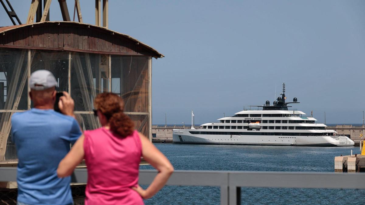 Dos ciudadanos fotografían el crucero de gran lujo Emerald Sakara, en su primera visita al Puerto chicharrero.