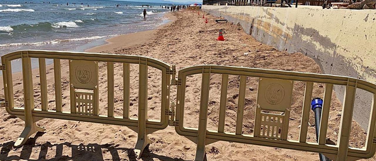 Una valla y varios conos impiden el acceso a la zona de playa donde el mar prácticamente se ha tragado la arena que depositó Costas en junio.