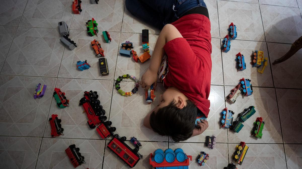 Un niño con autismo juega con su colección de trenes, el 16 de marzo pasado.