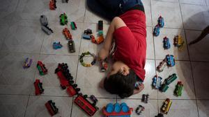 Un niño con autismo juega con su colección de trenes, el 16 de marzo pasado.